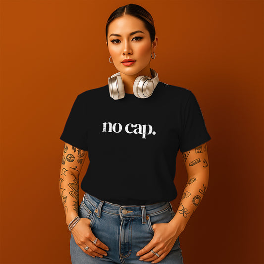A woman with tattoos on her arms and a black t-shirt with the text "no cap" stands against an orange background, wearing headphones around her neck.