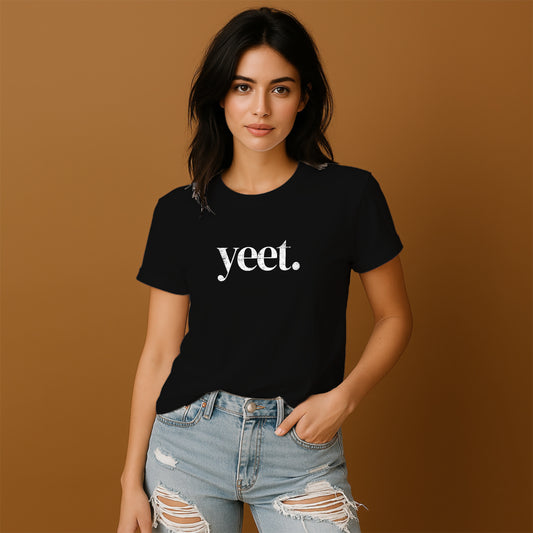 A young woman wearing a black t-shirt with the word "yet" printed on it, paired with distressed jeans, stands against a brown background.