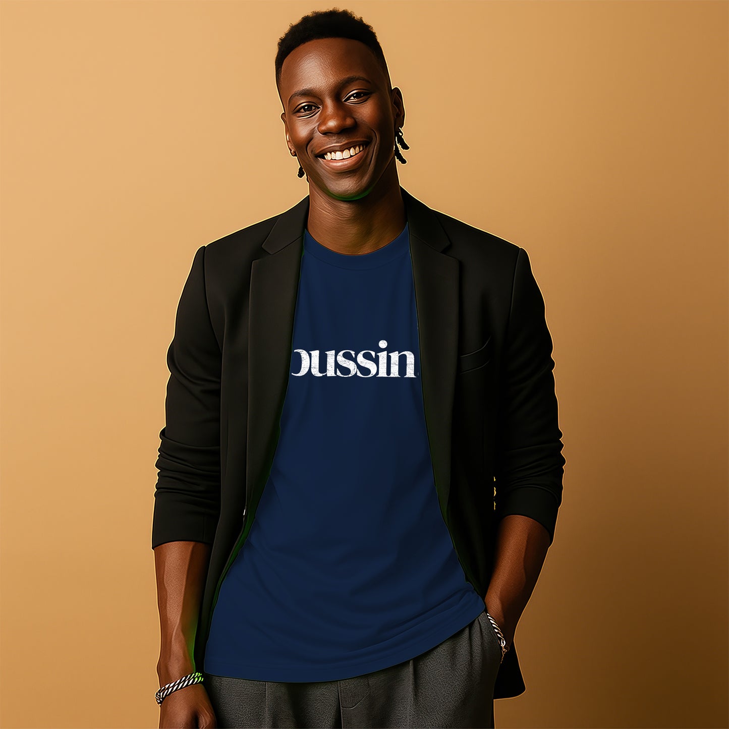 A smiling man wearing a black blazer and a blue t-shirt with the word "DUSSIN" printed on it.