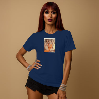 A woman with long red hair wearing a navy blue t-shirt with a framed photo of three people on it, posing confidently against a beige background.