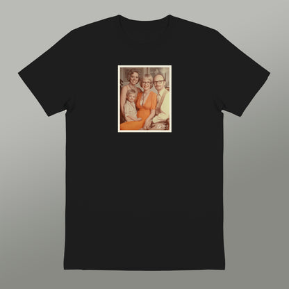 A black t-shirt with a framed photograph of a family, including a woman, a child, and two other individuals, displayed on the front.