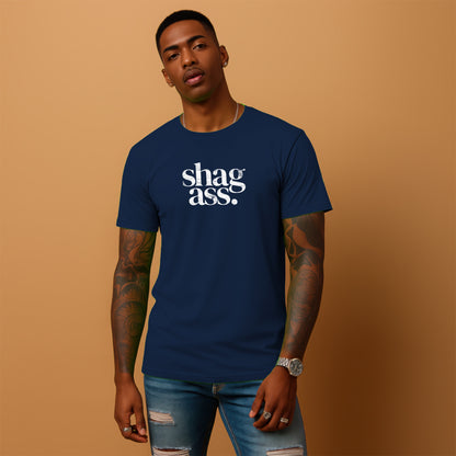 A man wearing a navy blue t-shirt with the text "shag ass" printed on it, standing against a peach-colored background.