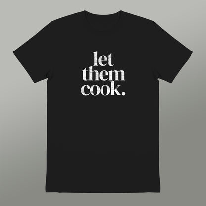 A black t-shirt with the text "let them cook" printed in white on it.