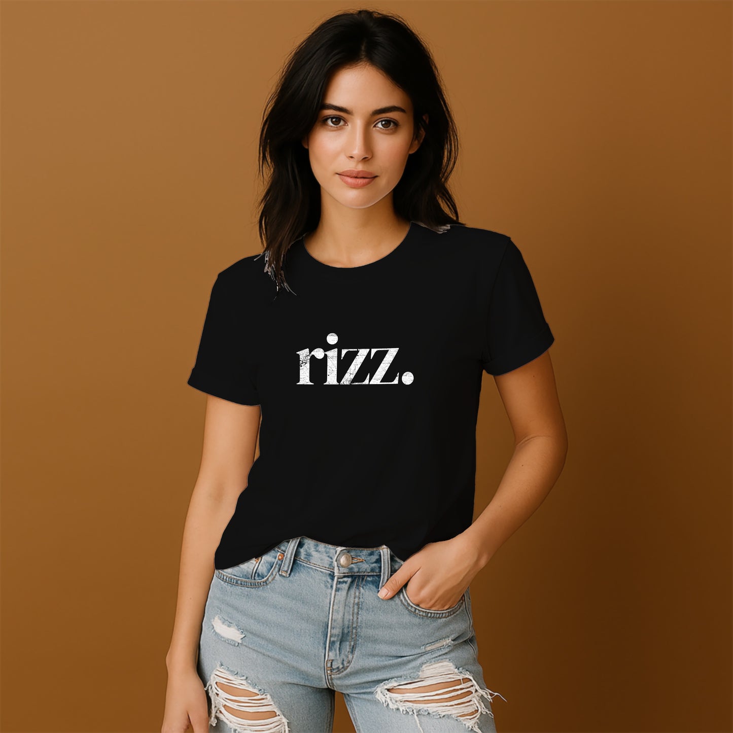 A young woman wearing a black t-shirt with the word "Razz" printed on it, paired with distressed jeans, stands against a brown background.