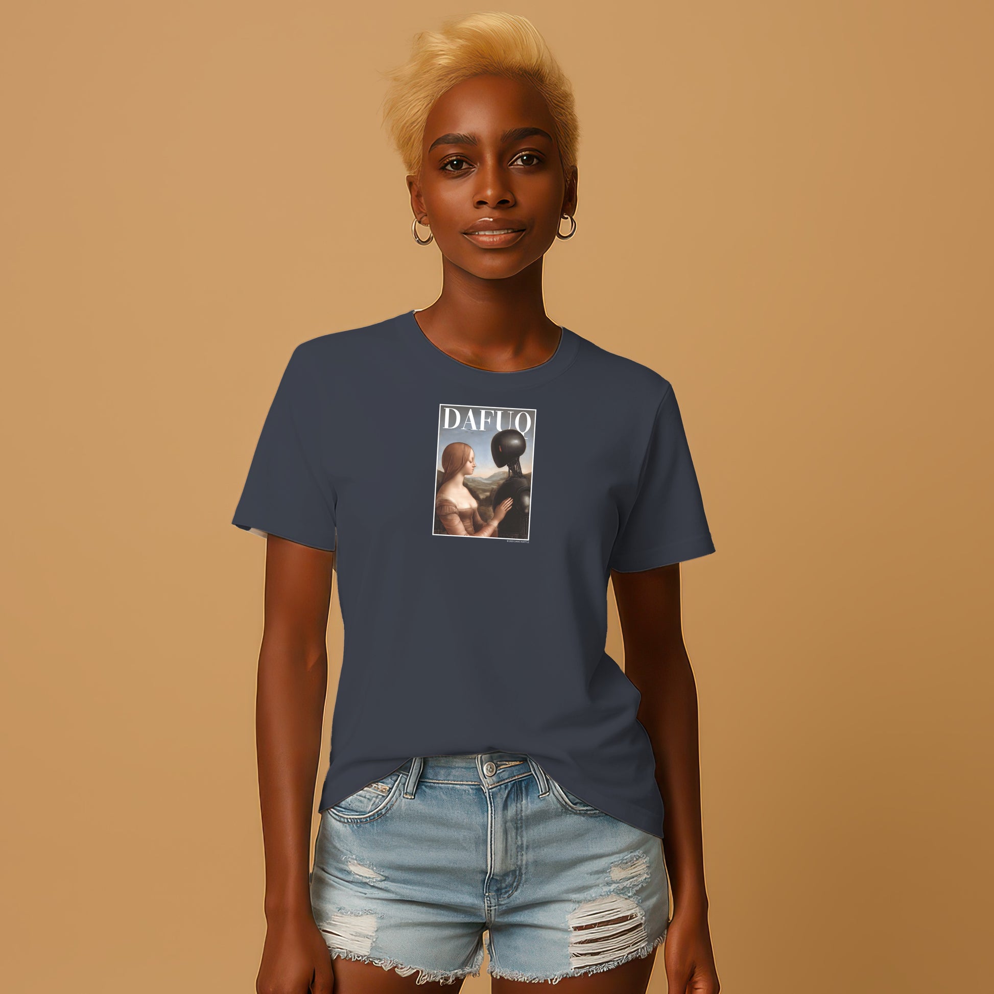 A woman with blonde hair wearing a navy blue t-shirt with a graphic design and denim shorts stands against a beige background.