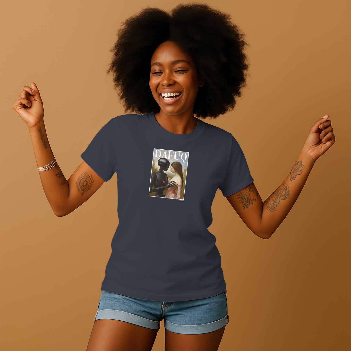 A smiling woman with curly hair wearing a dark blue t-shirt with a graphic design on it, standing against a beige background.
